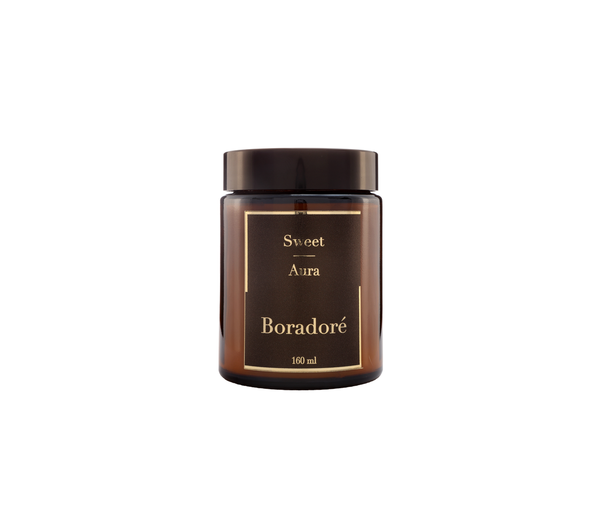 Boradoré Sweet Aura scented candle in amber glass jar on white background
