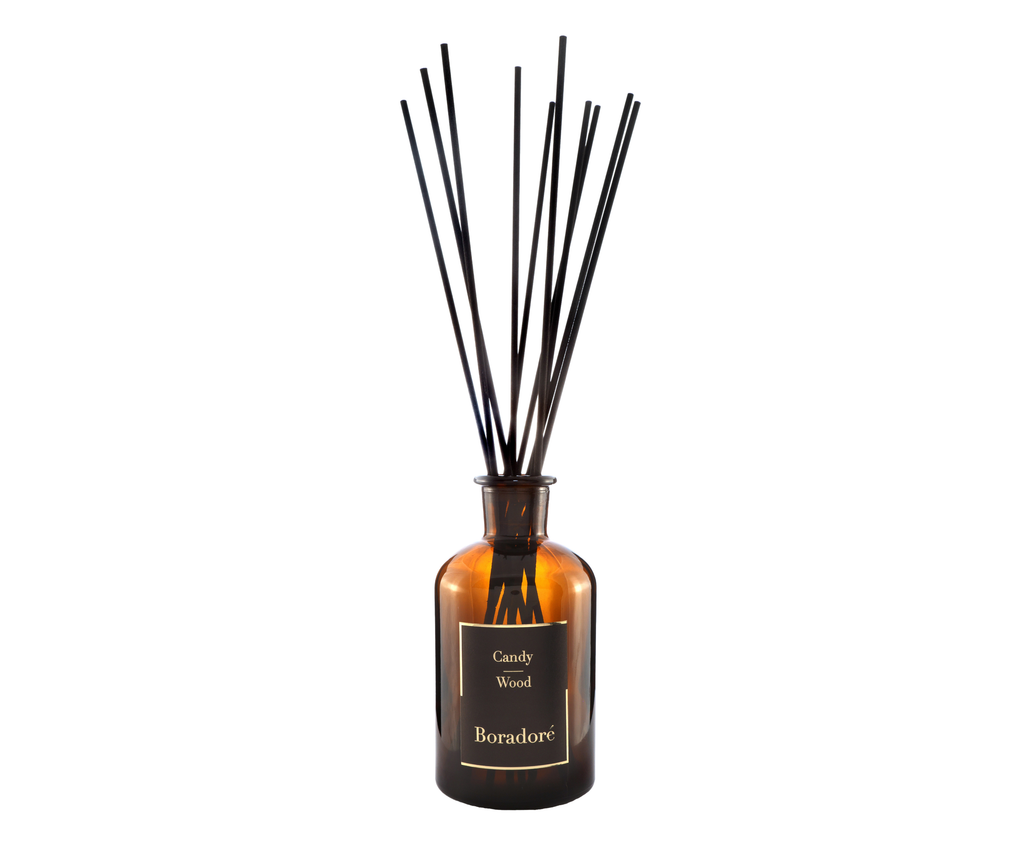 Boradoré Candy Wood reed diffuser in amber glass bottle on white background

