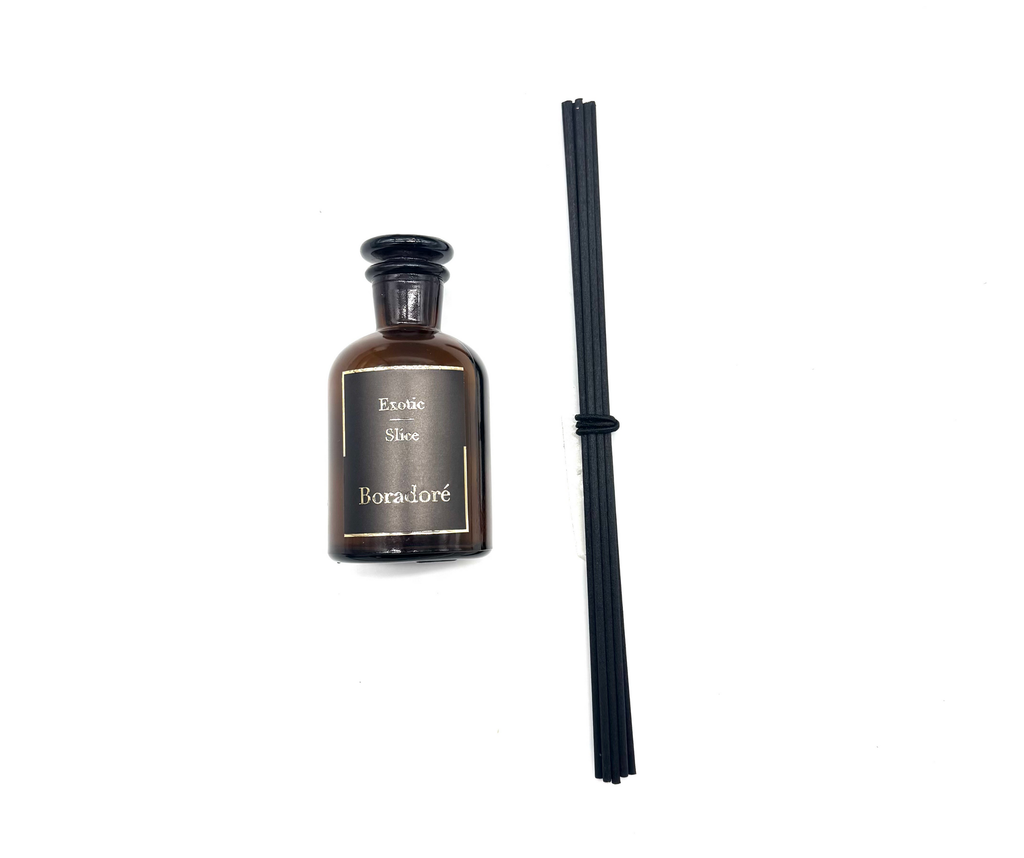 Boradoré Exotic Slice reed diffuser bottle with black reeds on a white background