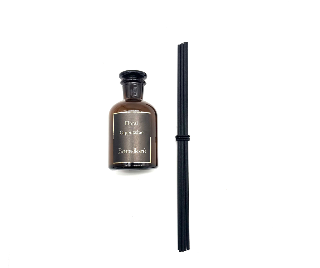 Boradoré Floral Cappuccino reed diffuser bottle with black reeds on a white background
