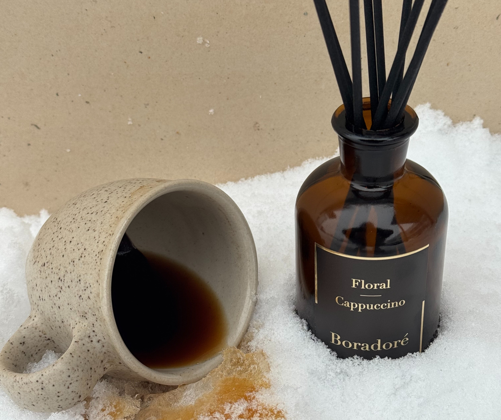 Boradoré Floral Cappuccino reed diffuser with a ceramic coffee cup styled in snow
