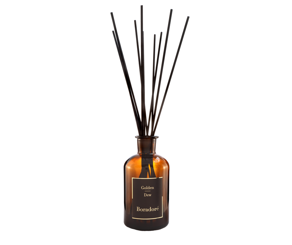 Boradoré Golden Dew reed diffuser in amber glass bottle on white background
