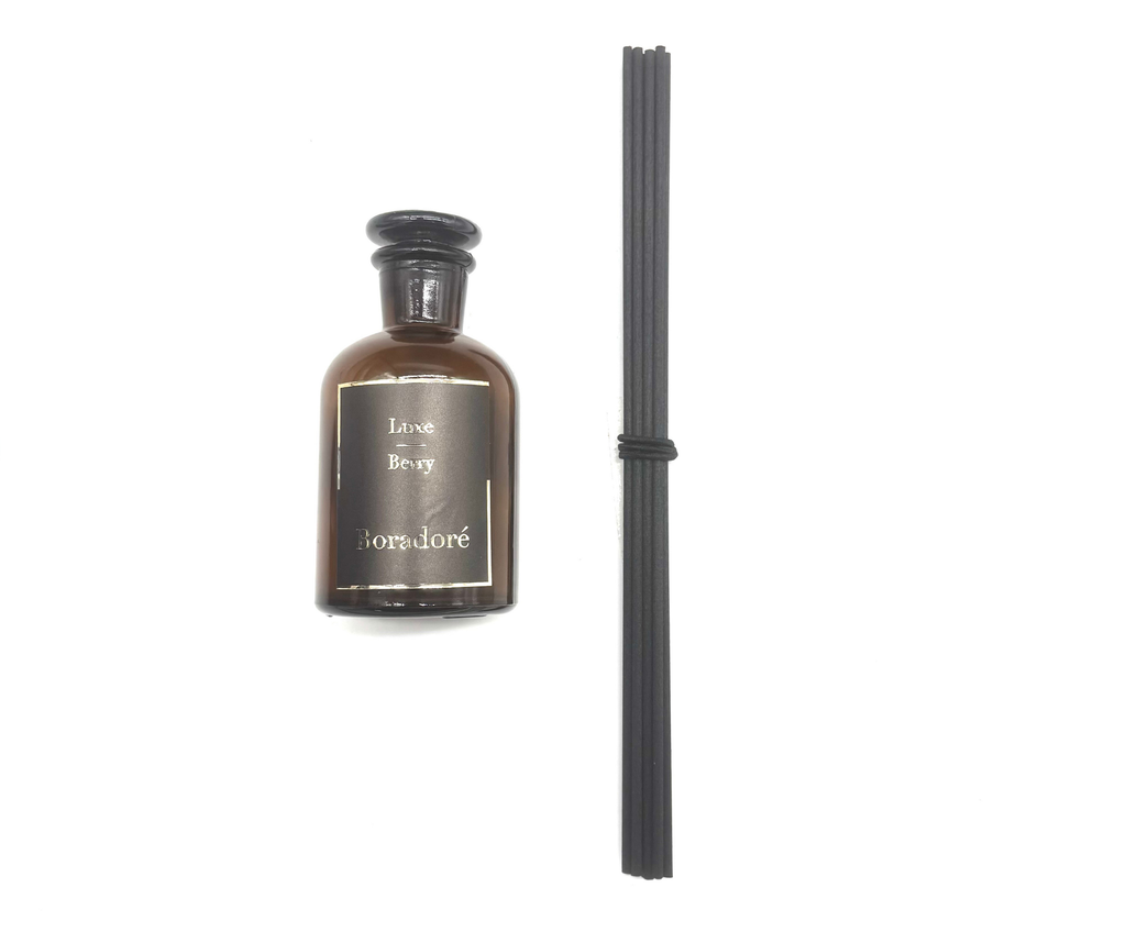 Boradoré Luxe Berry reed diffuser in amber glass bottle on white background
