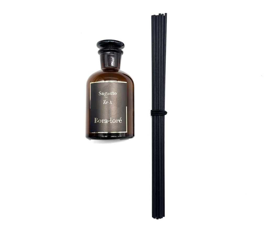 Boradoré Sagunto Zest reed diffuser in amber glass bottle with black reeds on white background
