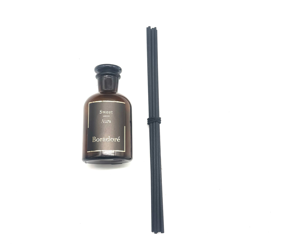 Boradoré Sweet Aura reed diffuser bottle with black reeds on a white background
